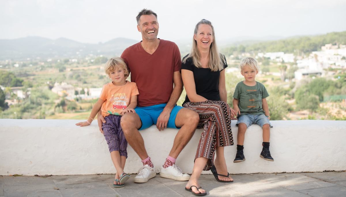 Gezin van vier geniet lachend van een uitzicht; symboliseert energie en familiebalans dankzij herstel van Hashimoto en trage schildklier.”