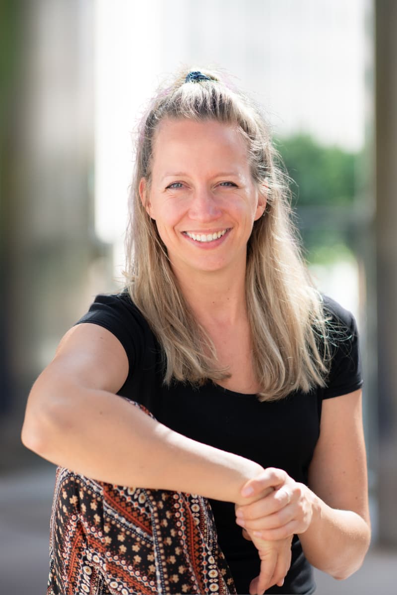 Marloes Mulder glimlacht buiten; portret van Hashimoto- en trage-schildklier specialist voor online begeleiding, gericht op herstel, afvallen en gewichtsverlies.